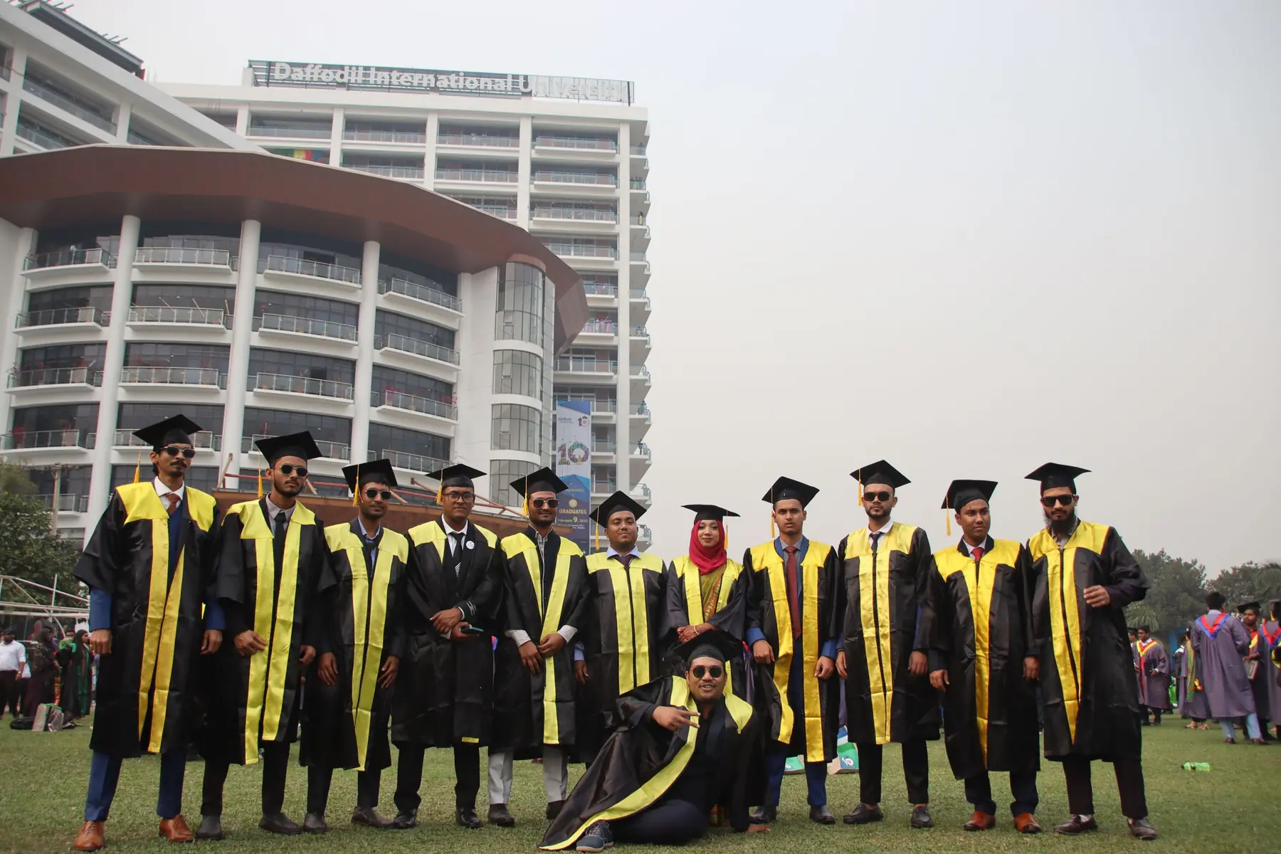 Graduates in gowns celebrating in front of a university building